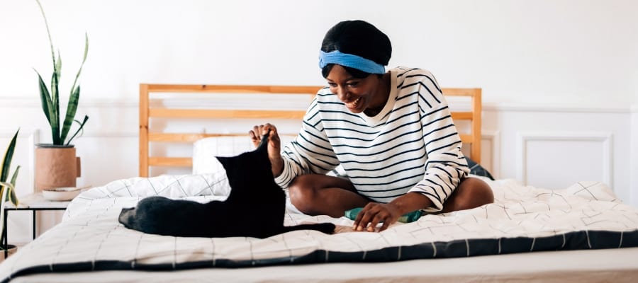woman and cat sitting on bed